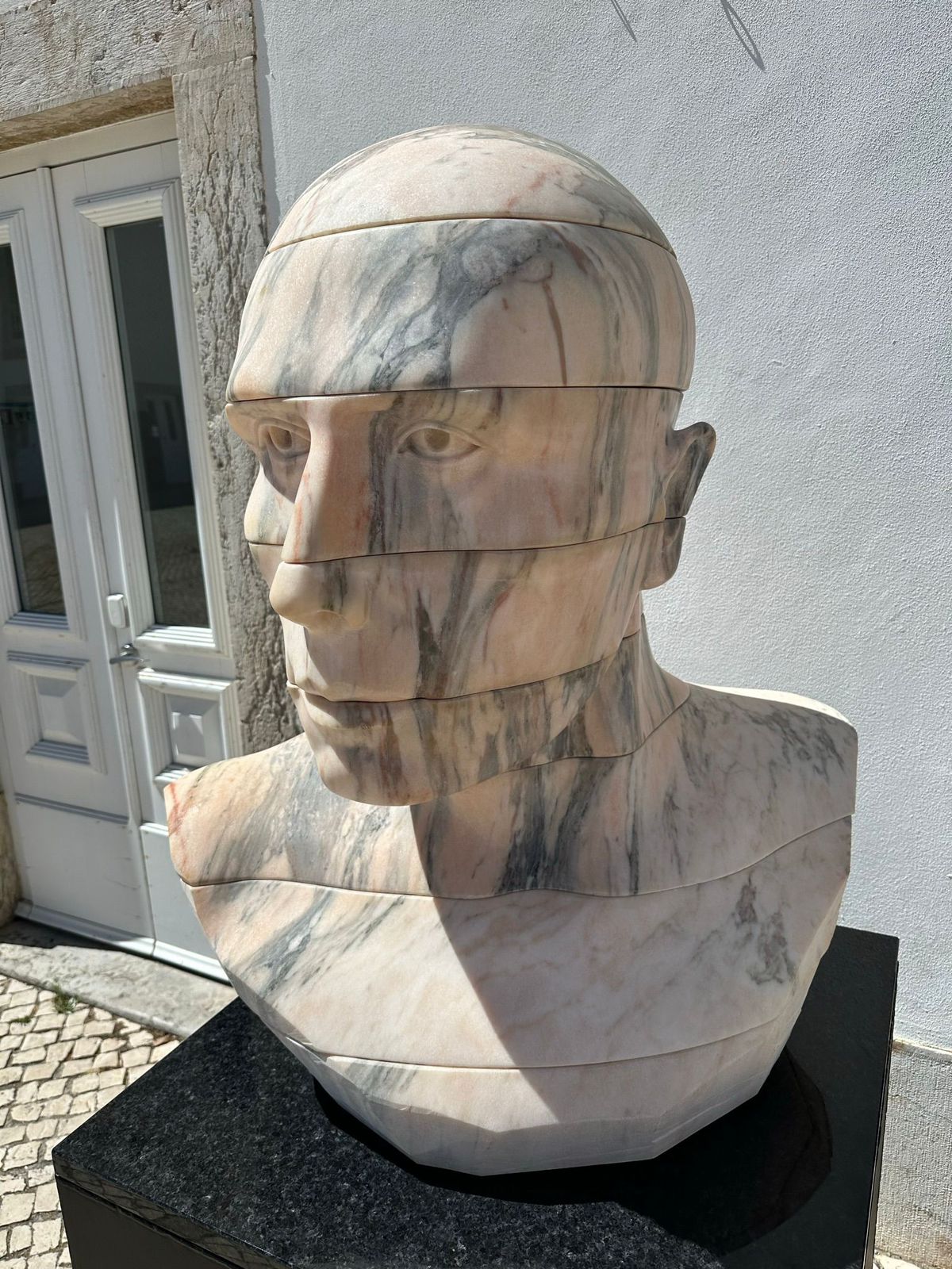Classical marble bust sculpture positioned outside a residential entry, reflecting Logan Wing’s appreciation for architecture and design.